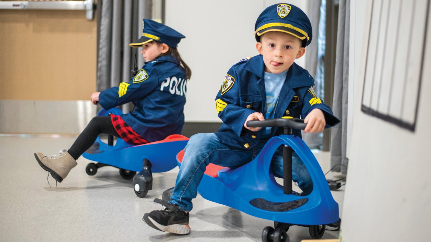 Skylar Wiemann and Cole West, kindergarten students at  James W. Lintott Elementary School, sport police uniforms in Scooter Town Tuesday morning.