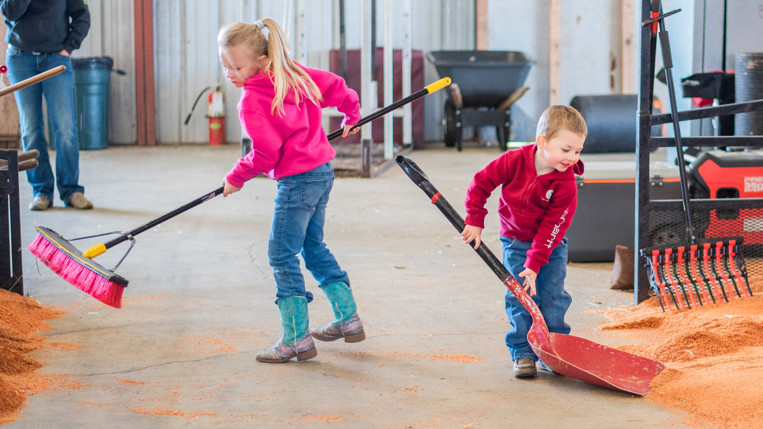 Ella Hylton, 5, and her brother Lane, 3, use a broom and shovel as they prep for the Spring Youth Fair Friday morning at the Southwest Washington Fairgrounds in Centralia.