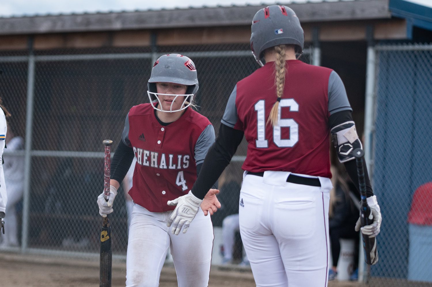 W.F. West outfielder Lena Fragner (4) high-fives Kamy Dacus (16) after scoring a run against Rochester April 29.