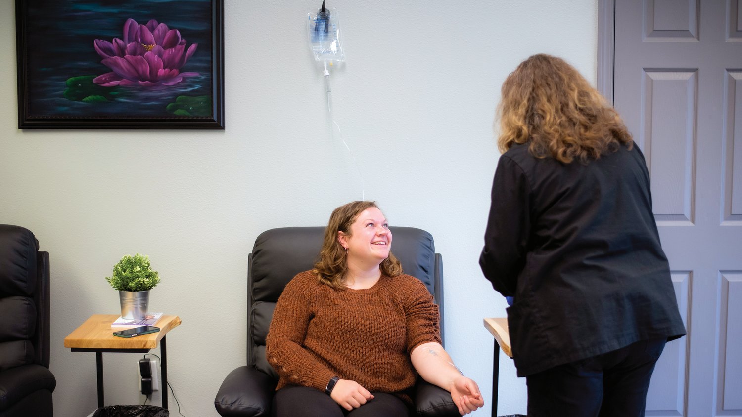 Office Manager Mikayla Rockey smiles while receiving an infusion Tuesday at Evexia Northwest in Centralia.