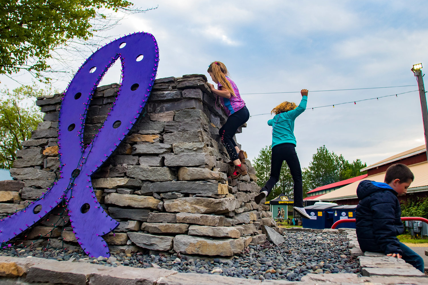 FILE PHOTO — Children climb around a purple ribbon decoration during the Relay For Life at the Southwest Washington Fairgrounds.