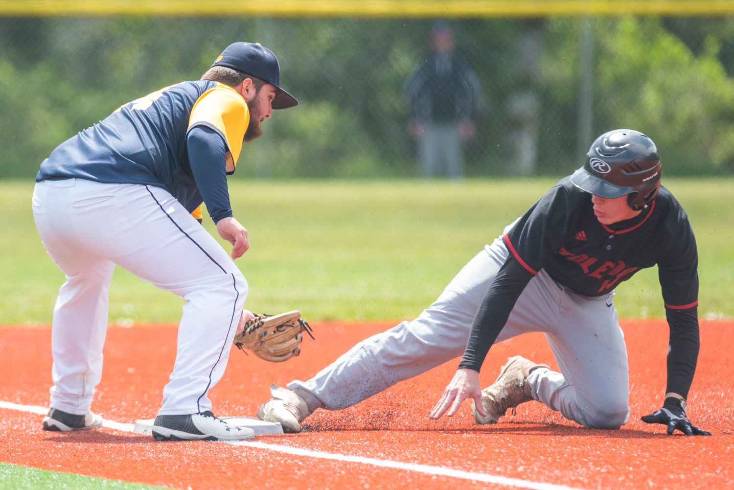 Toledo's Geoffrey Glass, right, slides safely into third base during a district-playoff win over Ilwaco on May 7.