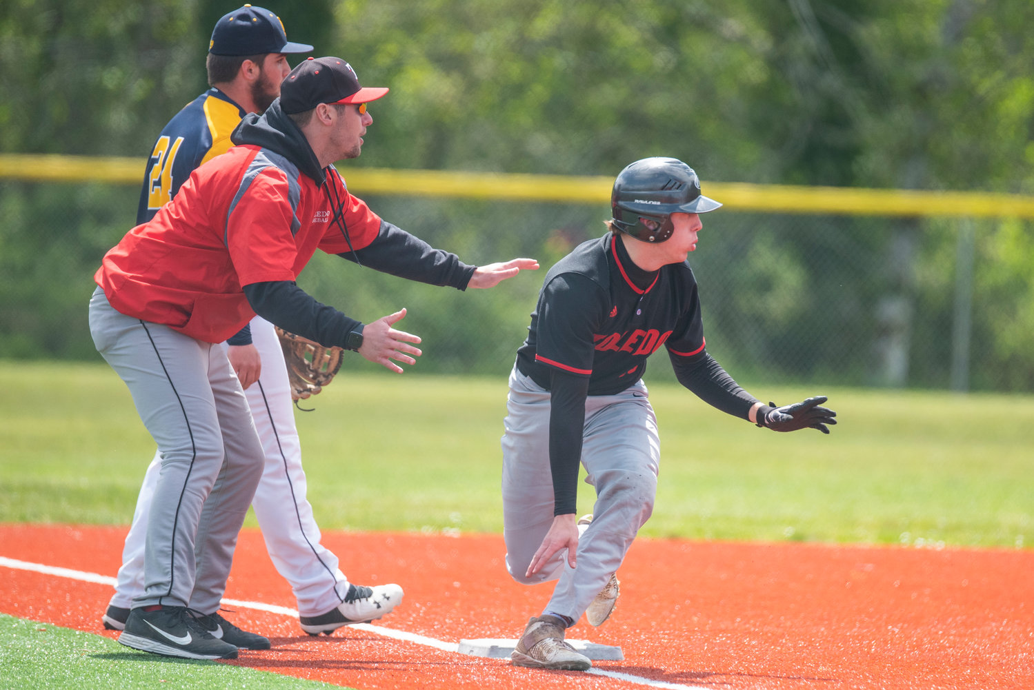 Toledo baserunner Geoffrey Glass, right, watches toward second base and contemplates sprinting home during a playoff win over Ilwaco on May 7.