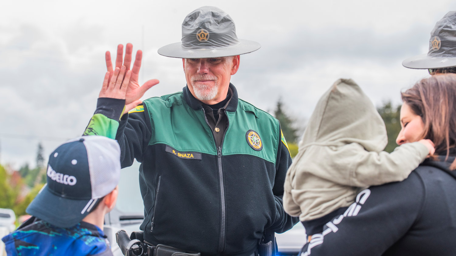 Sheriff Rob Snaza receives a high-five during the Vader May Day Parade Saturday morning.