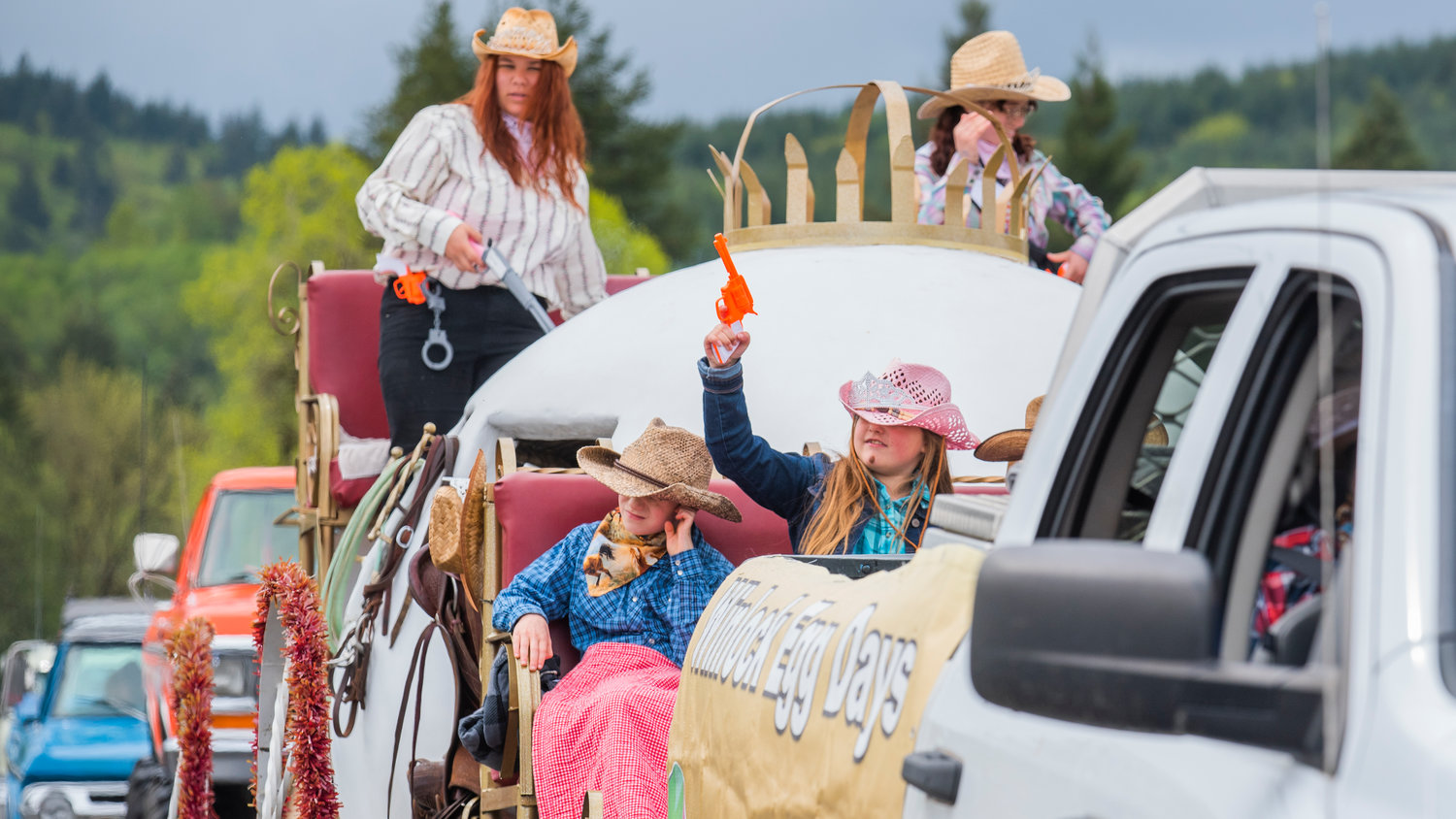 Prop guns are held up from the Winlock Egg Days float during the Vader May Day Parade Saturday morning.