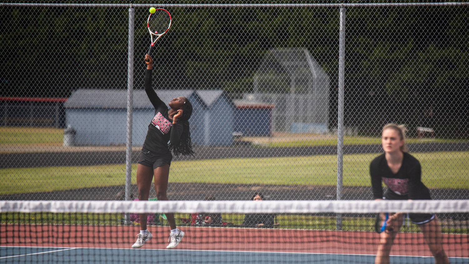 W.F. West’s Mariama Ceesay serves alongside her partner Kaylynne Dowling during a doubles match at A.G. West Black Hills High School Tuesday afternoon in Tumwater.