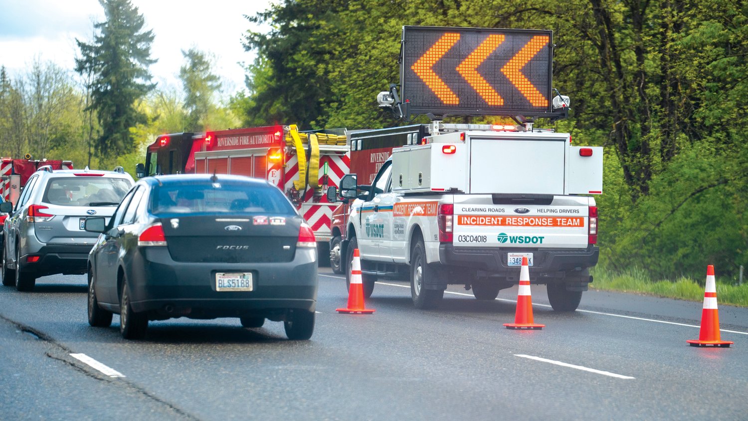 Members of the WSDOT Incident Response Team block one lane of Interstate 5 as ambulance crews and fire engines respond to a car fire in the southbound lane of Interstate 5 near milepost 86 in Grand Mound on Tuesday.