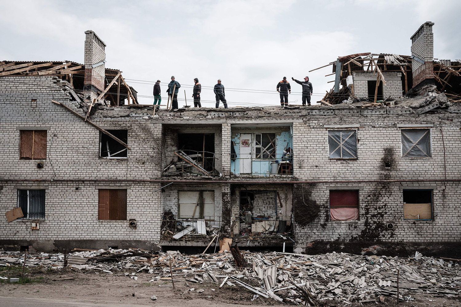 Workers clean rubbles atop a buidling destroyed by shelling a month ago in Cherkaske, eastern Ukraine on May 11, 2022, amid the Russian invasion of Ukraine. (Yasuyoshi Chiba/AFP via Getty Images/TNS)