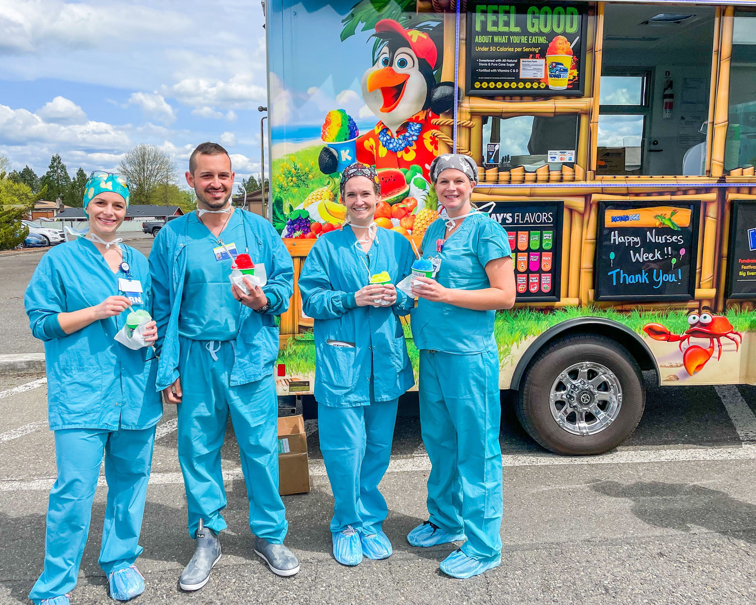 From left, Mallory, Brandon, Jessica and Amanda from Providence Centralia Hospital smile and pose for a photo in front of a Kona Ice truck Wednesday afternoon during a caregiver appreciation event.