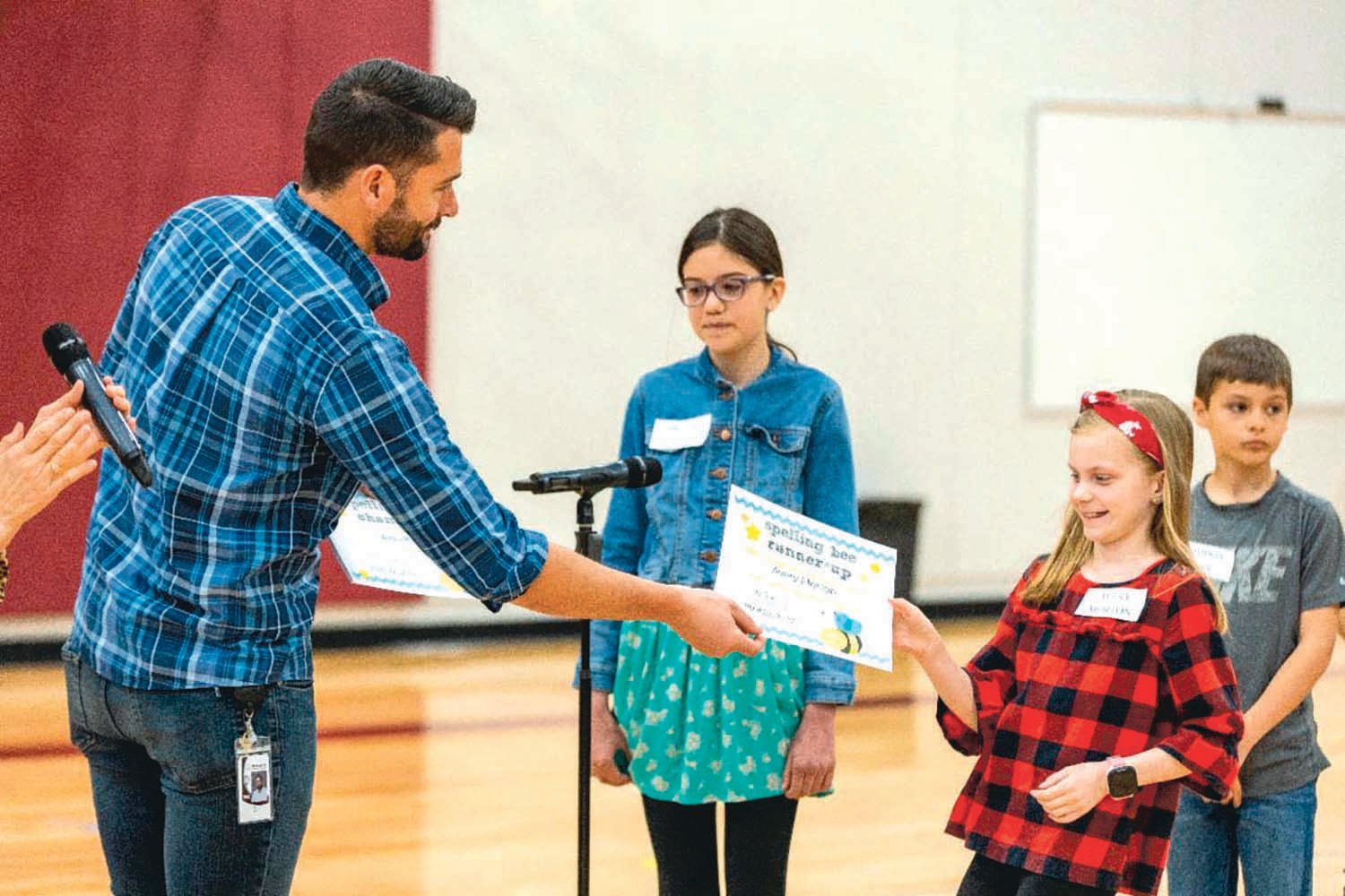 Avery Morton receives a certificate for placing fourth in Orin Smith Elementary’s spelling bee on April 29.
