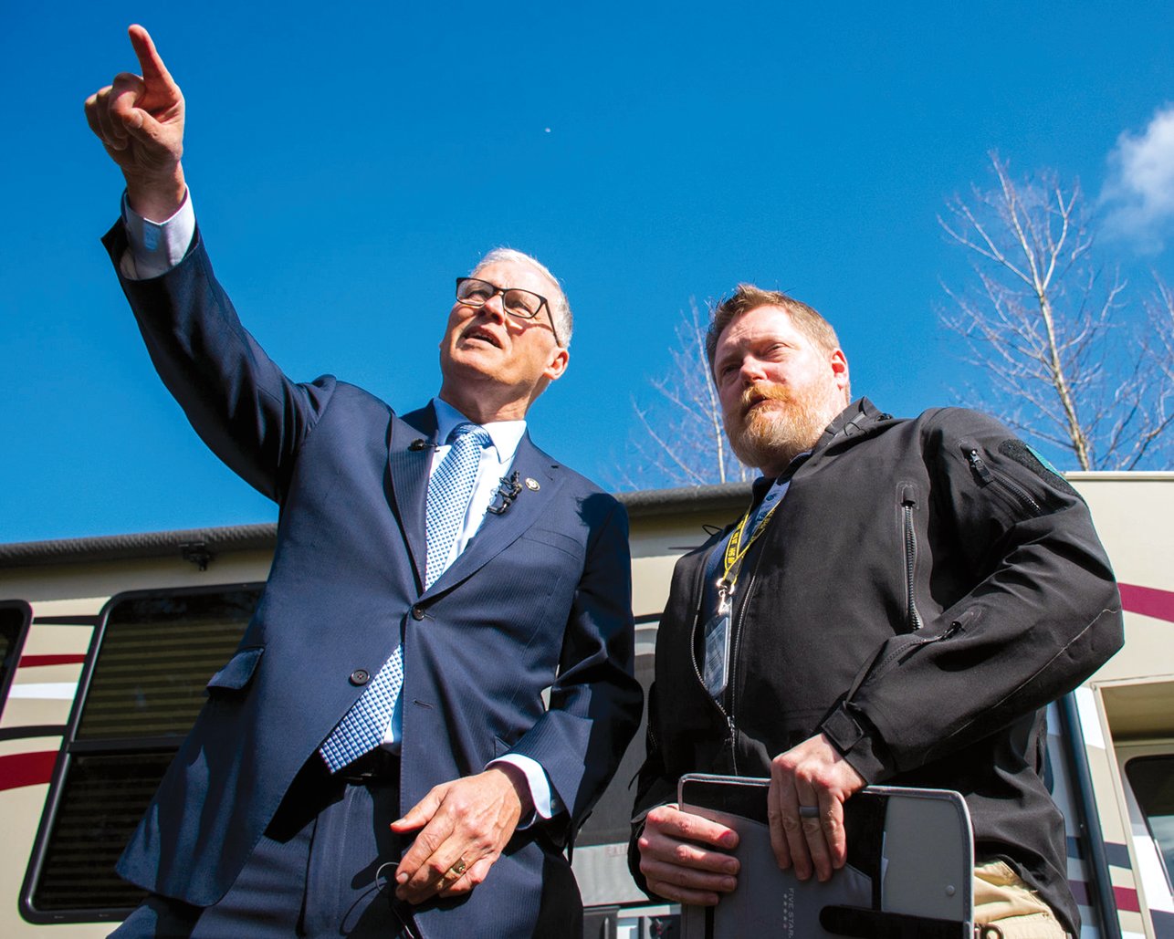 Gov. Jay Inslee points to the isolation area of a potential COVID-19 quarantine site during a tour with Washington State Department of Health Commander Nathan Weed at Maple Lane in early March 2020.