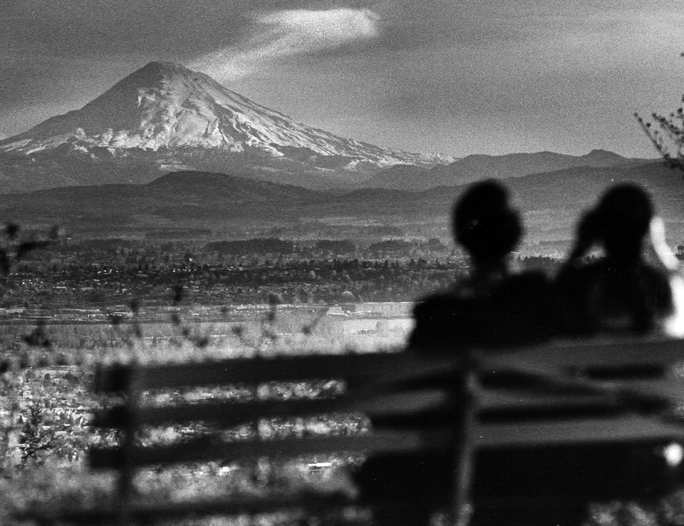 Clear air and a cloudless sky in April 1980 give a couple a fine view of Mount St. Helens from the grounds of Pittock Mansion in Portland's northwest hills. The mountain would erupt a month later. (The Oregonian)