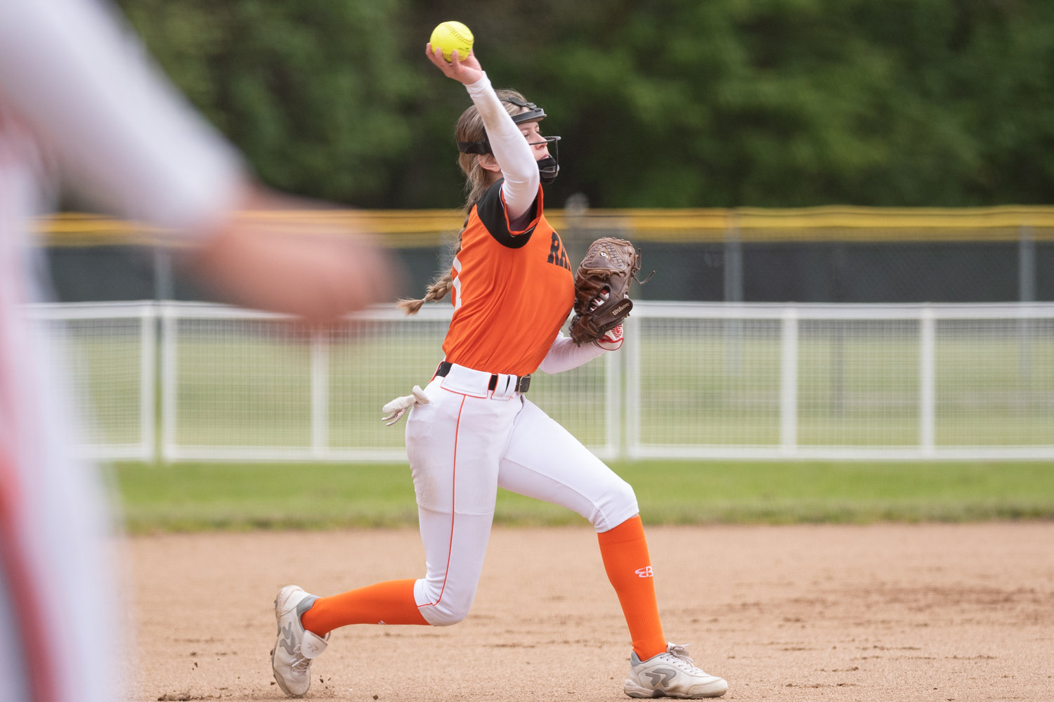 Rainier third baseman Olivia Earsley slings a ball toward first for an out against Forks in the 2B District 4 tournament at Fort Borst Park May 20.