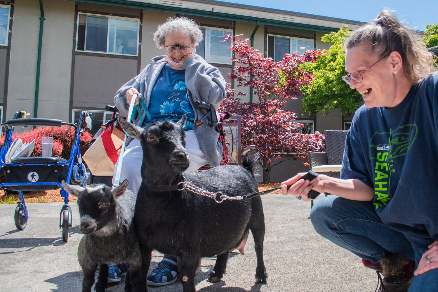 Grace Stratton and Sundina Bryan smile while holding pygmy goats by the lead at Woodland Village Concepts of Chehalis Thursday afternoon.