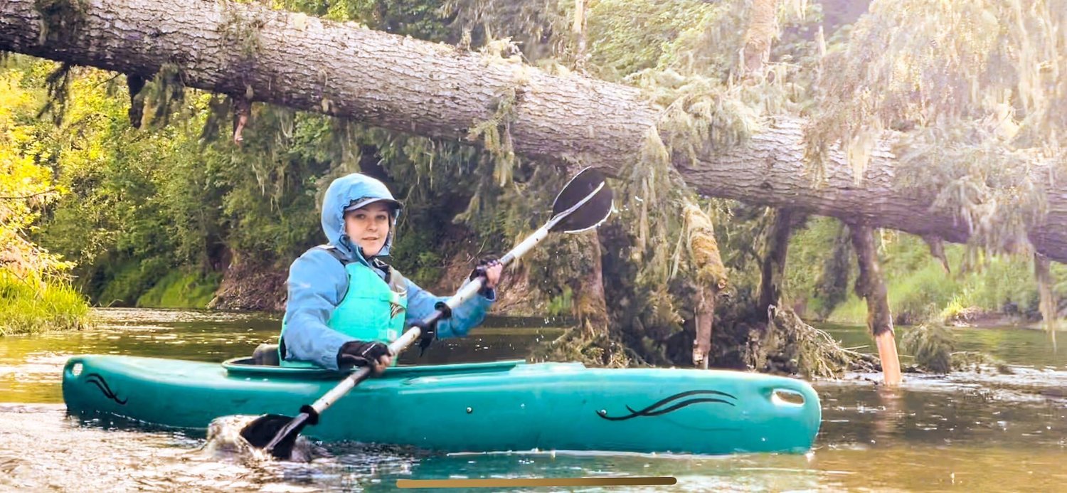 Reporter Isabel Vander Stoep paddles under a downed tree along the Chehalis River near Doty on Saturday.