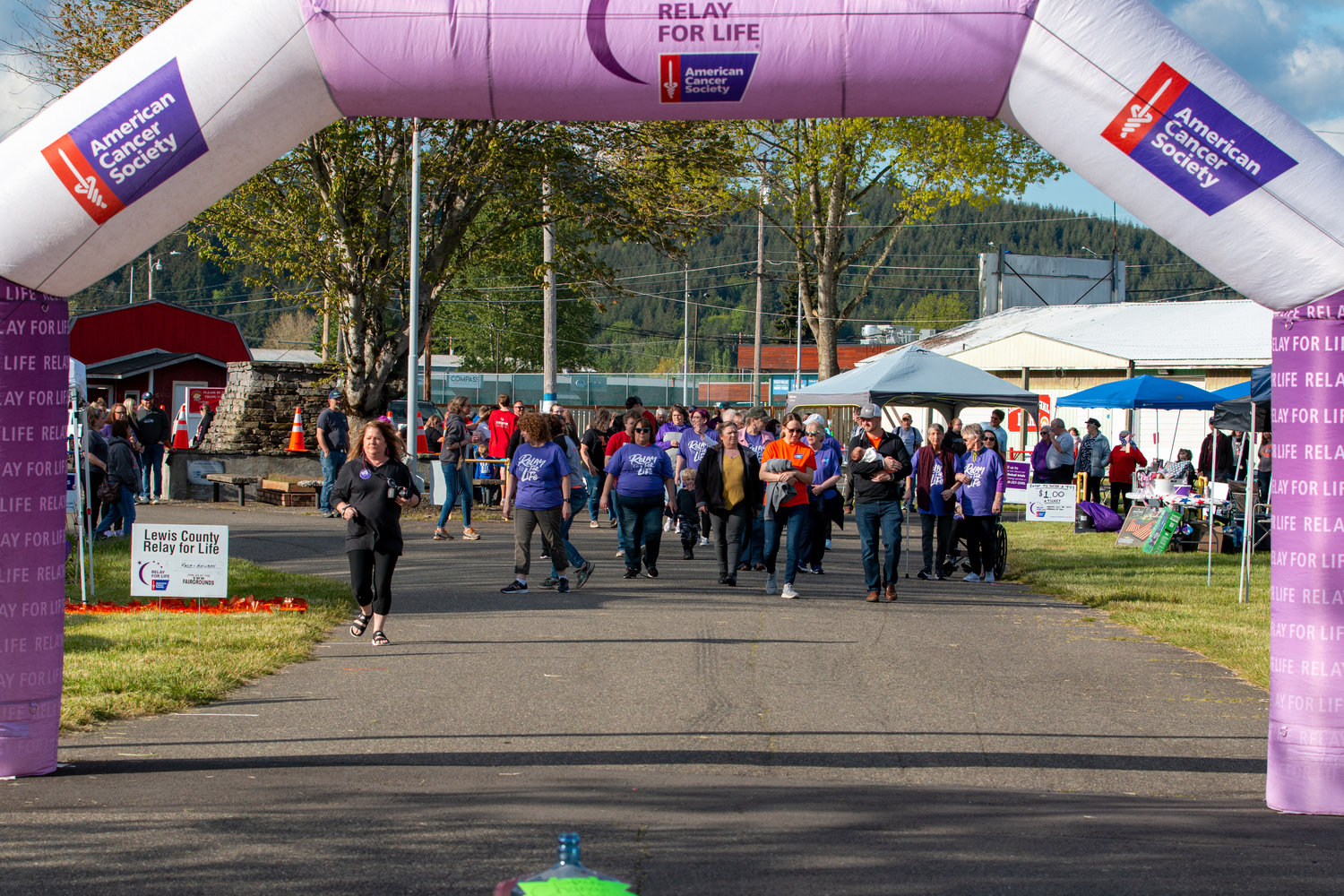 A large group of people start their first lap following the Family of the Year, Kyle and Kara Markstrom, at the Relay for Life event held at the Southwest Washington Fairgrounds Friday evening.