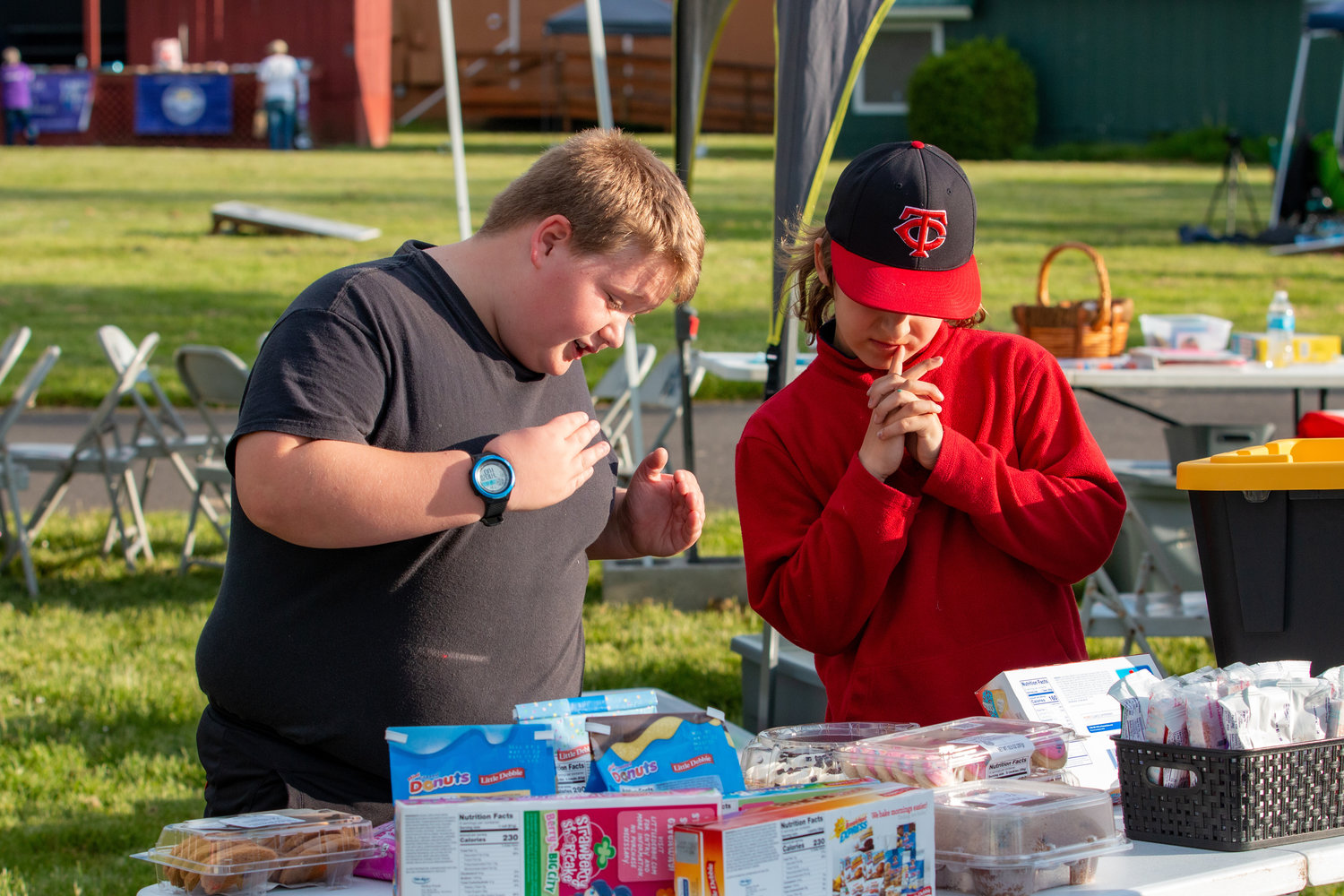 Two young boys discuss to one another which dessert would be the best choice after being a winner at the cake walk, held at the Relay for Life event at the Southwest Washington Fairgrounds Friday evening.