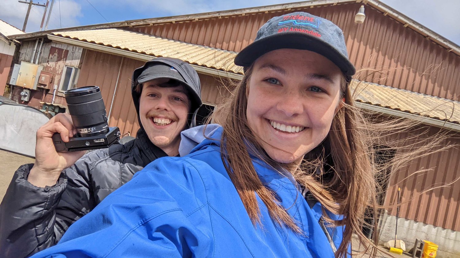 Reporters Jared Wenzelburger and Isabel Vander Stoep smile while riding on the back of a quad through a Satsop area farm.