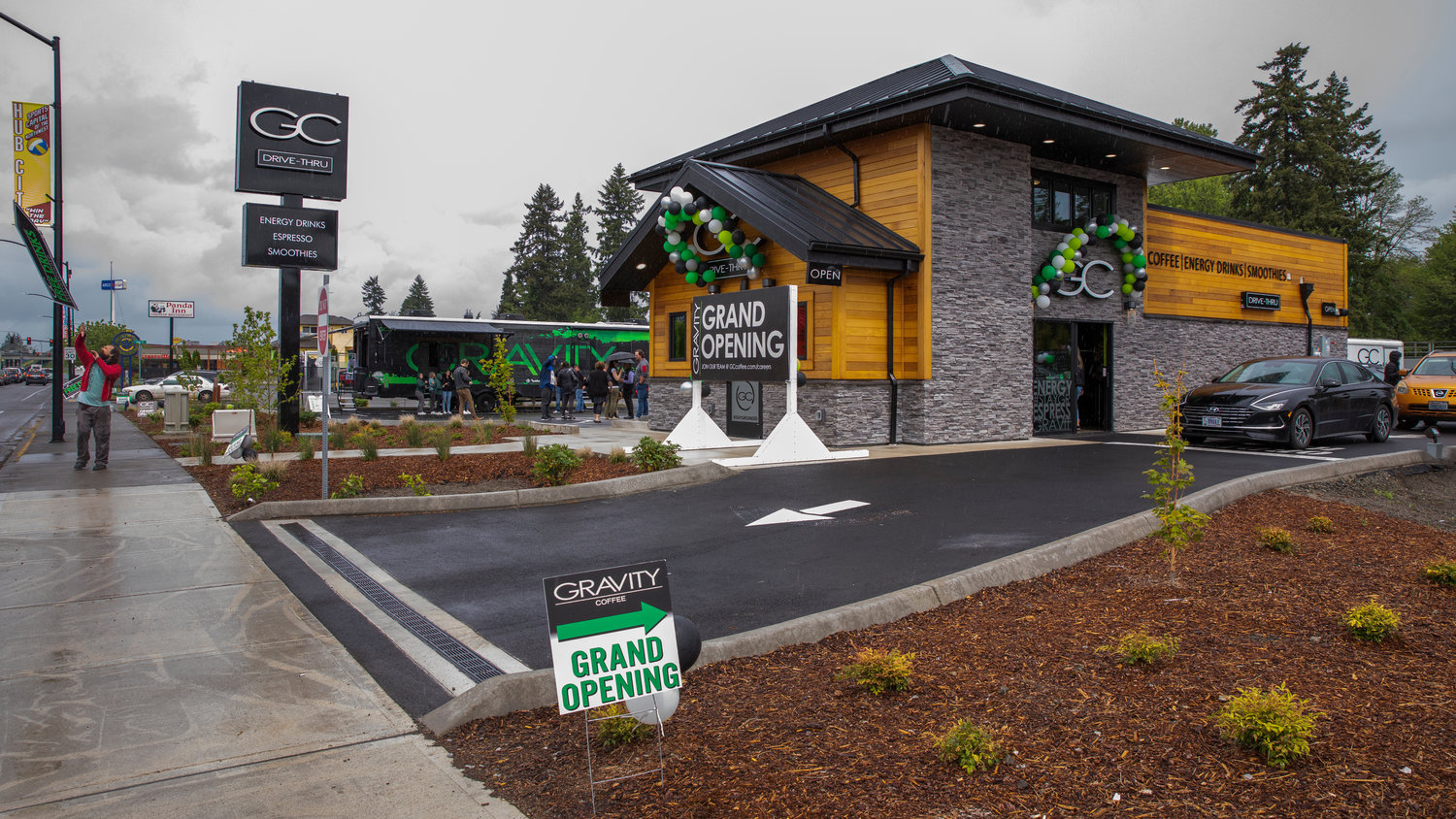 Music plays as signs are twirled and tossed into the air outside Gravity Coffee during a grand opening and ribbon-cutting ceremony Friday in Centralia. The business is located at 712 Harrison Ave., Centralia.