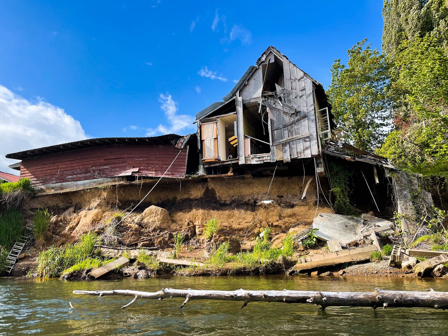 A dilapidated house crumbles into the Chehalis River along an eroded bank downstream of the Satsop River confluence.