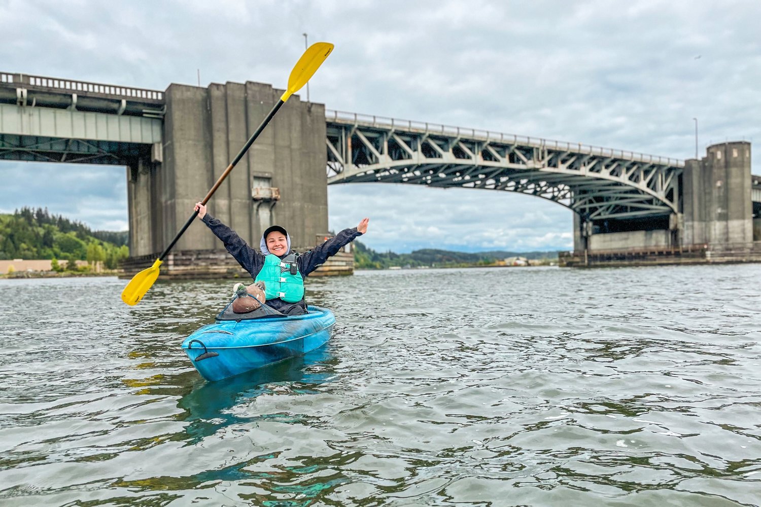 Reporter Isabel Vander Stoep holds up her paddle after kayaking under the Chehalis River Bridge in Aberdeen on Monday.