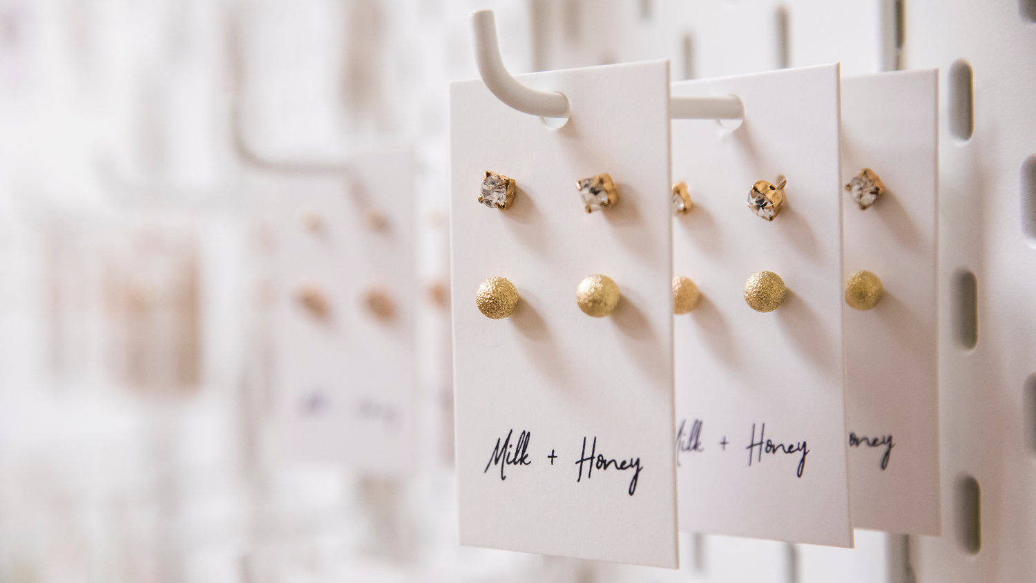 Earrings and other jewelry hang on display inside “Milk + Honey,” in Winlock.