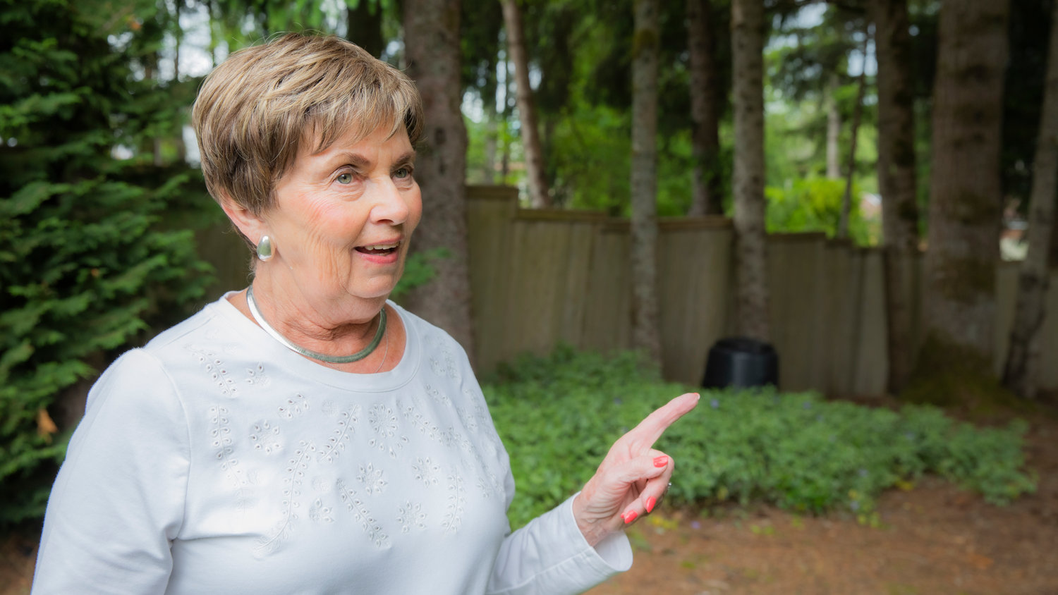 Margie Trentlage points to a crooked fence against trees she says the bear crawled over to get into her yard.