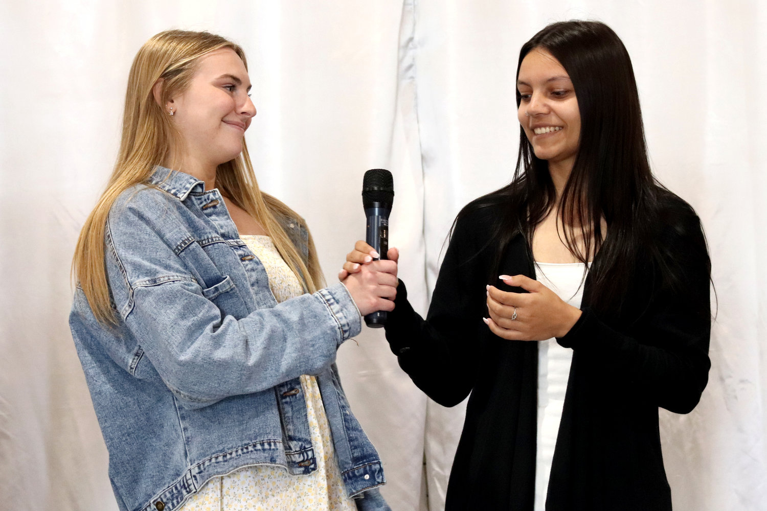 Centralia High School senior Hannah Robbins passes the mic to fellow Centralia senior Madelyn Sievert during the Rob Fuller Top 25 Luncheon in Chehalis on Monday. Both students plan to attend Centralia College.