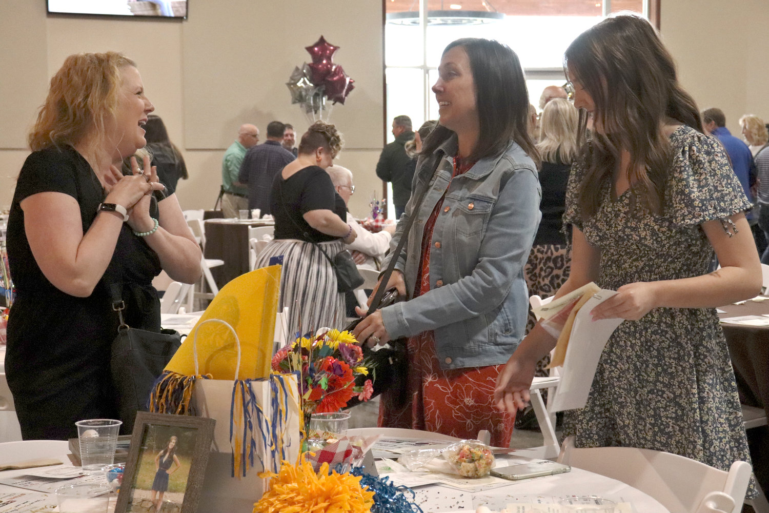 Suzie Mitchell, left, speaks with Olivia Mitchell Scholarship recipient Alyssa Davis, far right, during the Rob Fuller Top 25 Scholarship Luncheon in Chehalis on Monday. The award was available to Adna High School seniors.