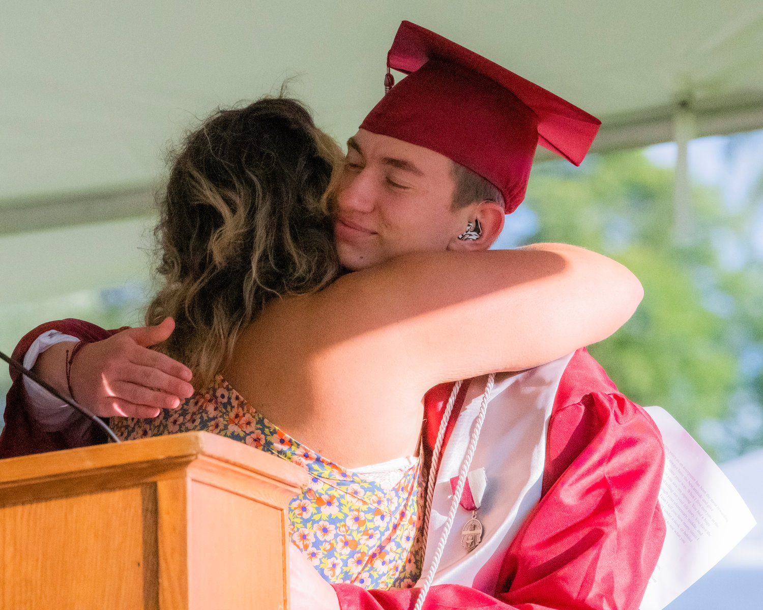 Joshua Eberly receives an embrace as he is honored with an award at Bearcat Stadium Saturday in Chehalis.