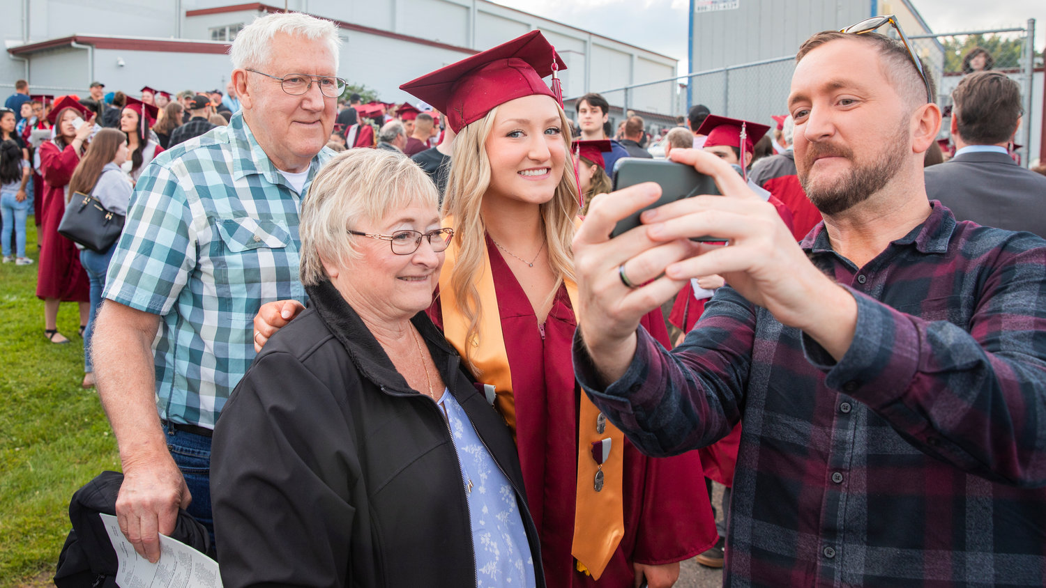 Graduates pose for photos with family outside W.F. West High School in Chehalis.