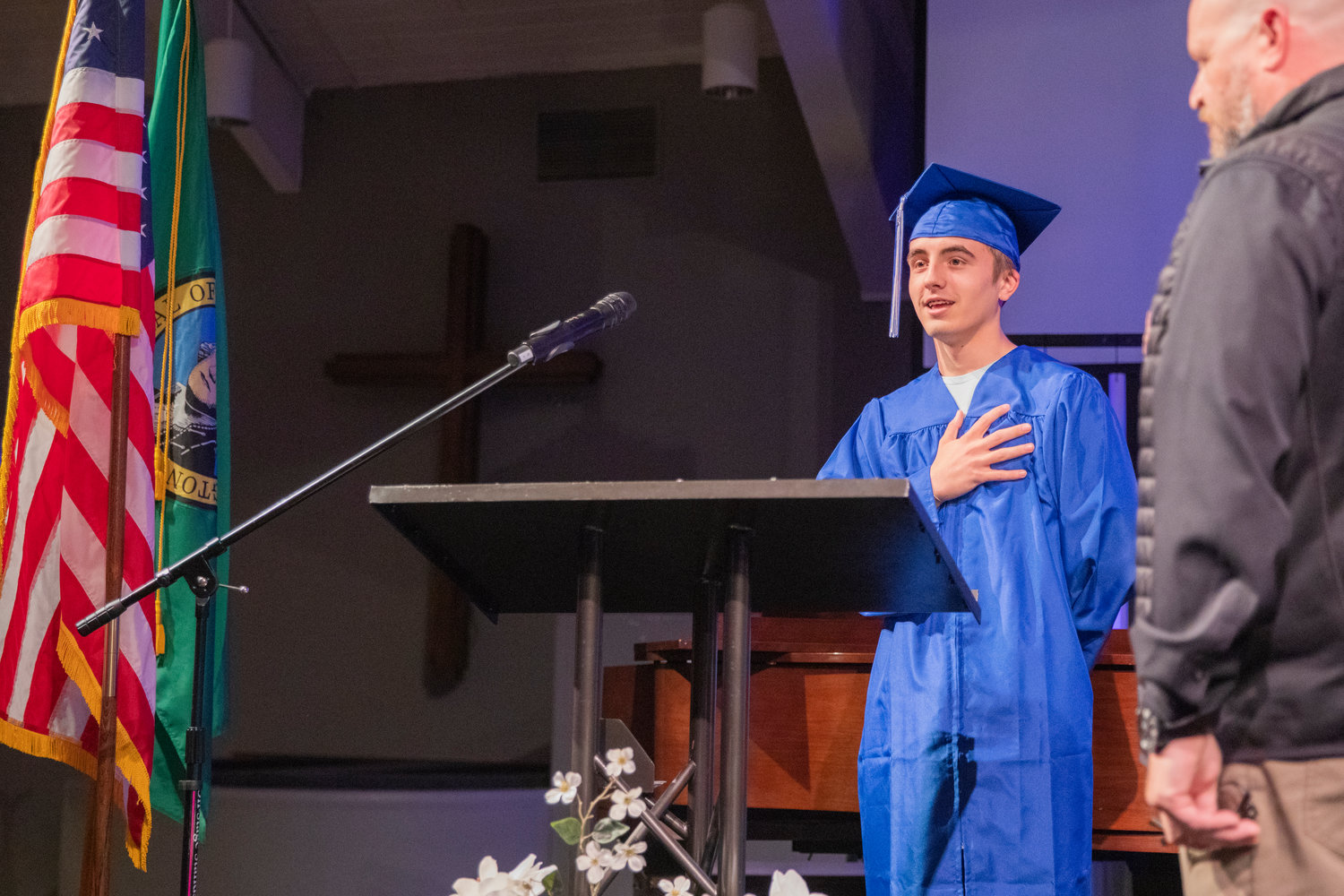 A graduate places his hand over his heart during a graduation ceremony for Futurus High School Tuesday in Centralia.
