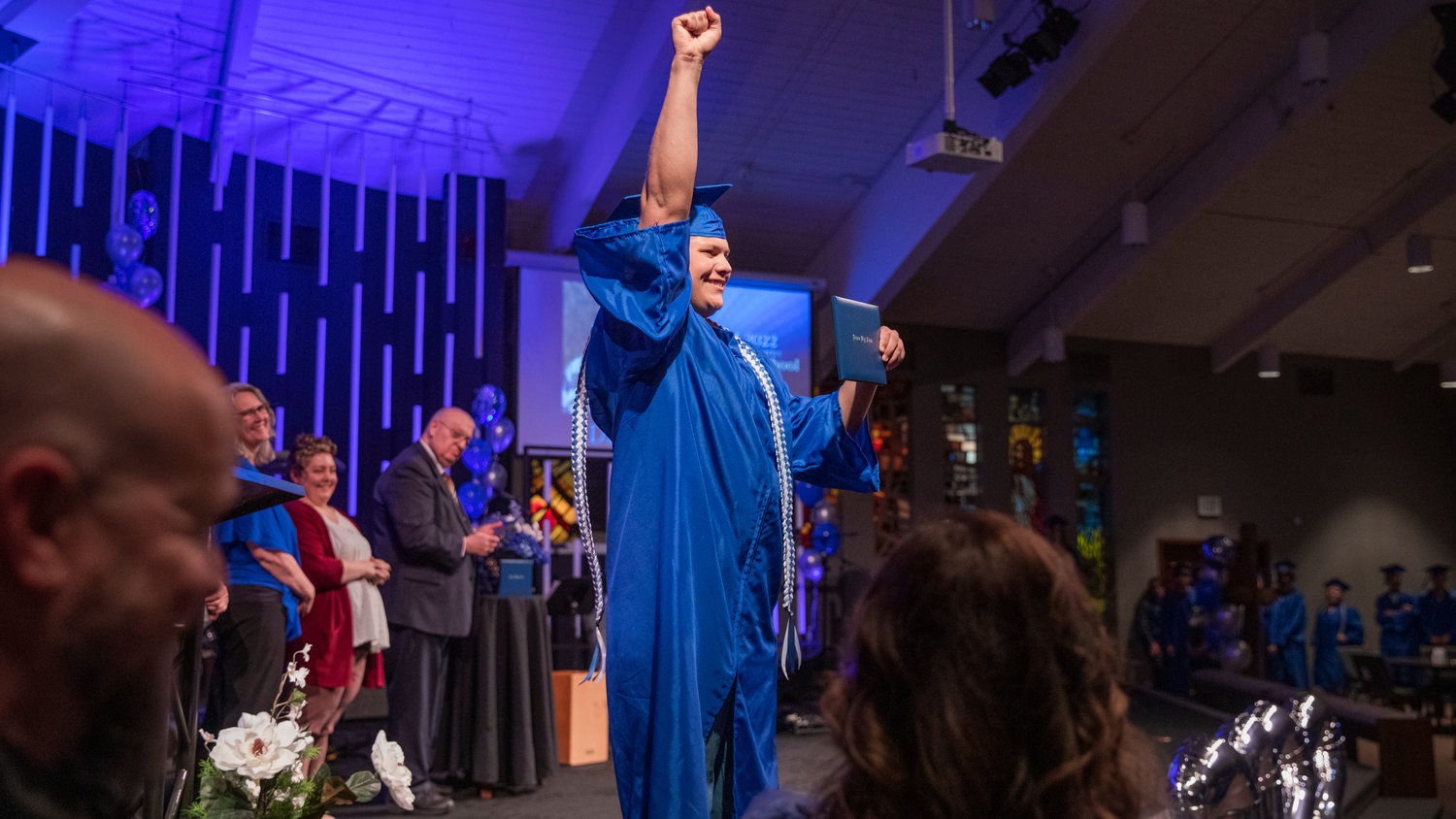 Daniel Lopez smiles and holds up his diploma to celebrate graduating from Futurus High School in Centralia on Tuesday.