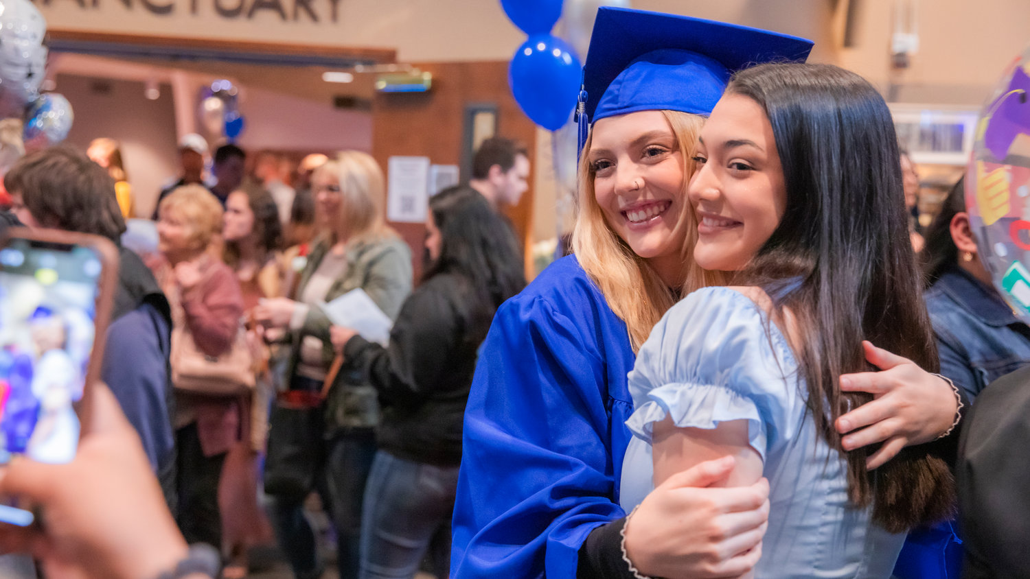 Presley Town smiles as she receives an embrace following a graduation ceremony for Futurus High School in Centralia Tuesday evening.
