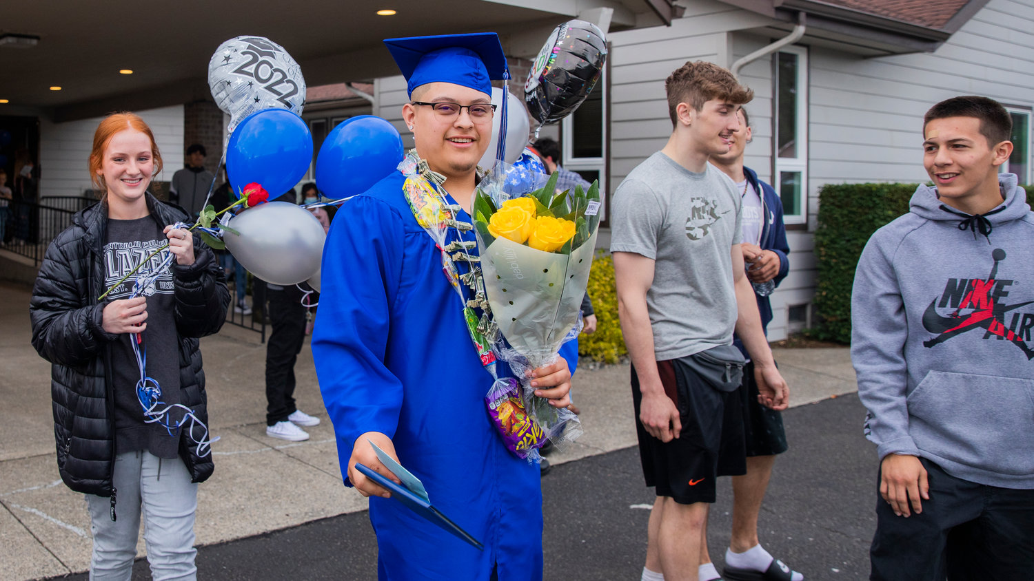 Futurus High School graduates walk with flowers and balloons in Centralia Tuesday evening.