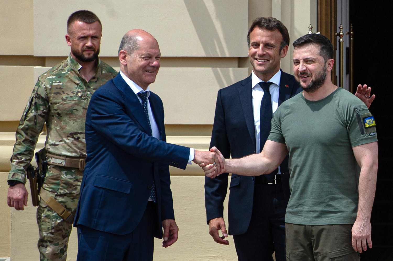 Ukrainian President Volodymyr Zelensky shakes hands with German Chancellor Olaf Scholz as France's President Emmanuel Macron taps him on the back on June 16, 2022 in Kyiv, Ukraine. (Alexey Furman/Getty Images/TNS)