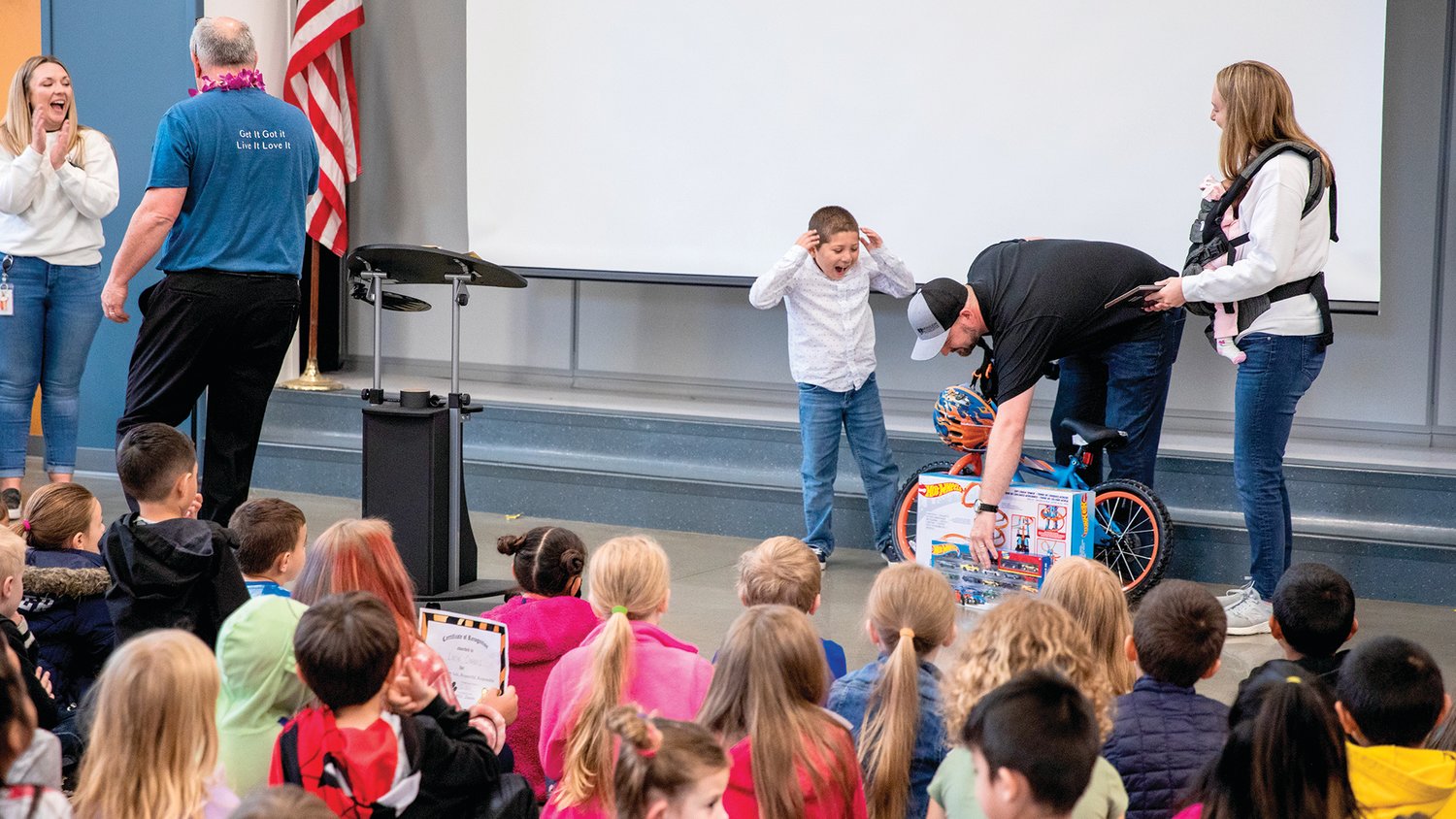 Yoe Rivas reacts as he is given a bike and Hot Wheels toys after being named the Noah Markstrom Award recipient Friday at Fords Prairie Elementary in Centralia.