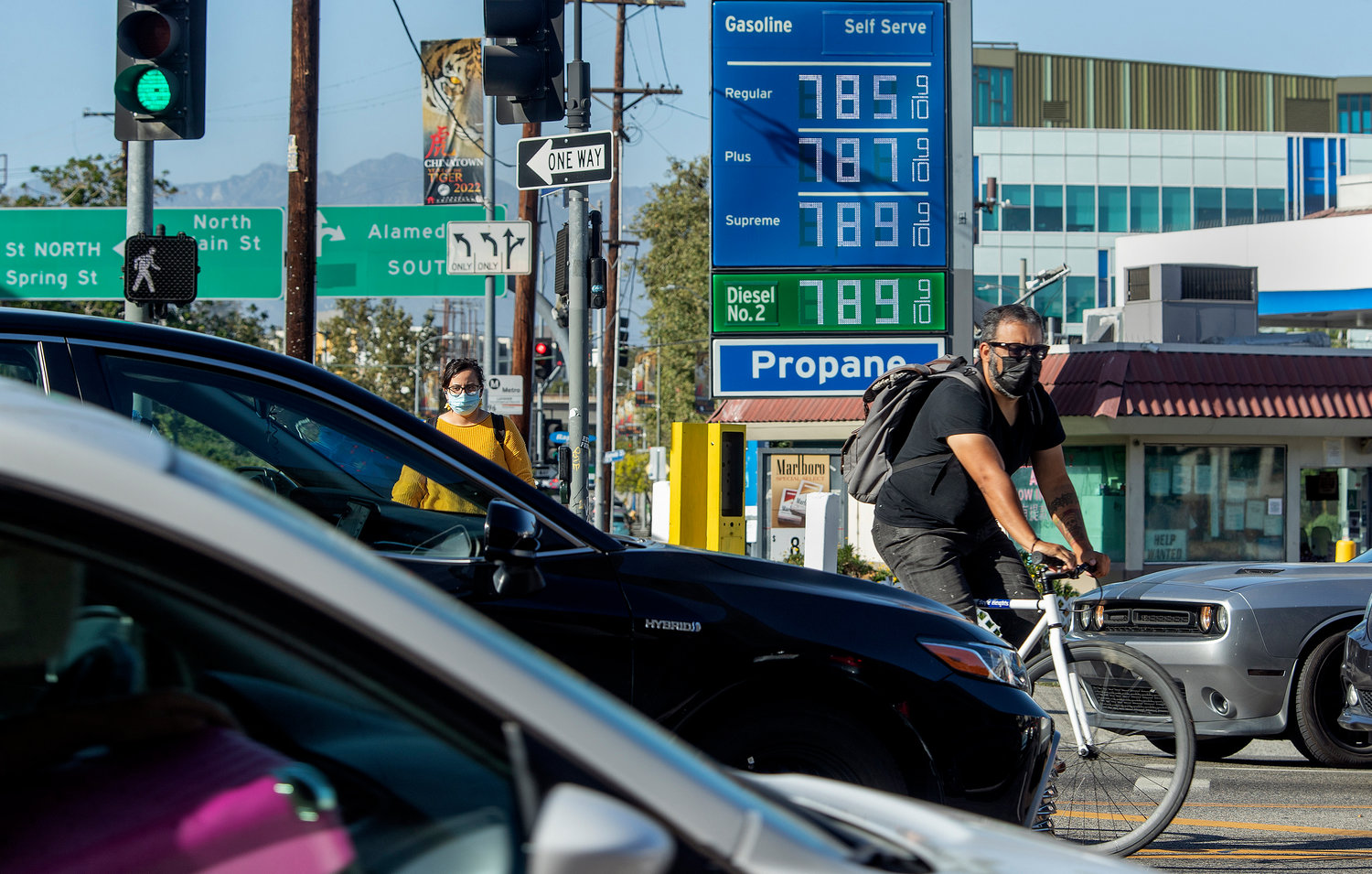 A bicycle rider maneuvers around motorists stuck in traffic on Cesar E. Chavez Avenue, at the intersection of Alameda Street, in downtown Los Angeles, where the price of gasoline approaches close to $8 a gallon at the Chevron gas station, June 1, 2022. (Mel Melcon/Los Angeles Times/TNS)