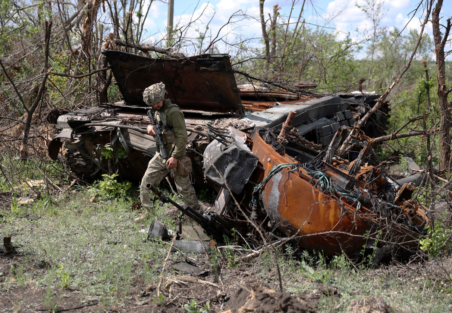 A Ukrainian serviceman inspects a destroyed Russian tank at an abandonned Russian position near the village of Bilogorivka not far from Lysychansk, Lugansk region, on June 17, 2022. (Anatolii Stepanov/AFP/Getty Images/TNS)