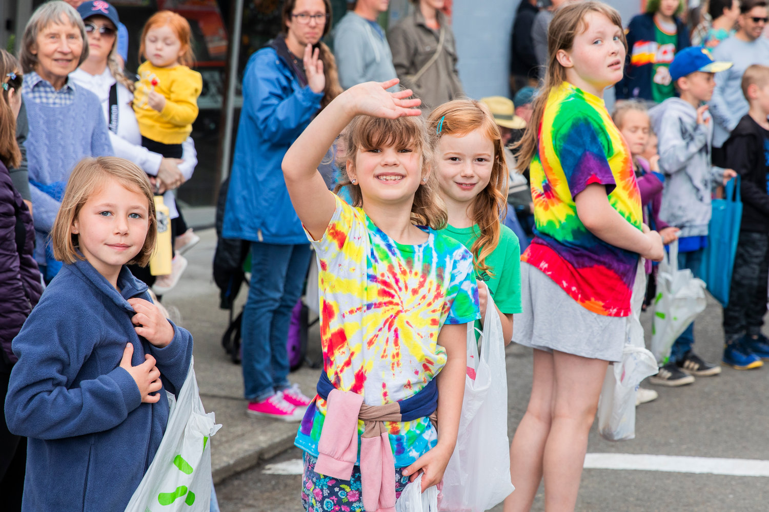 Kids smile and wave with bags full of candy during the Egg Days Festival parade in Winlock on Saturday.