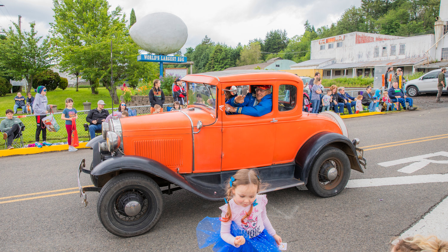 Candy is thrown from vintage cars in front of the “World’s Largest Egg,” during the Egg Days Festival parade in Winlock on Saturday.