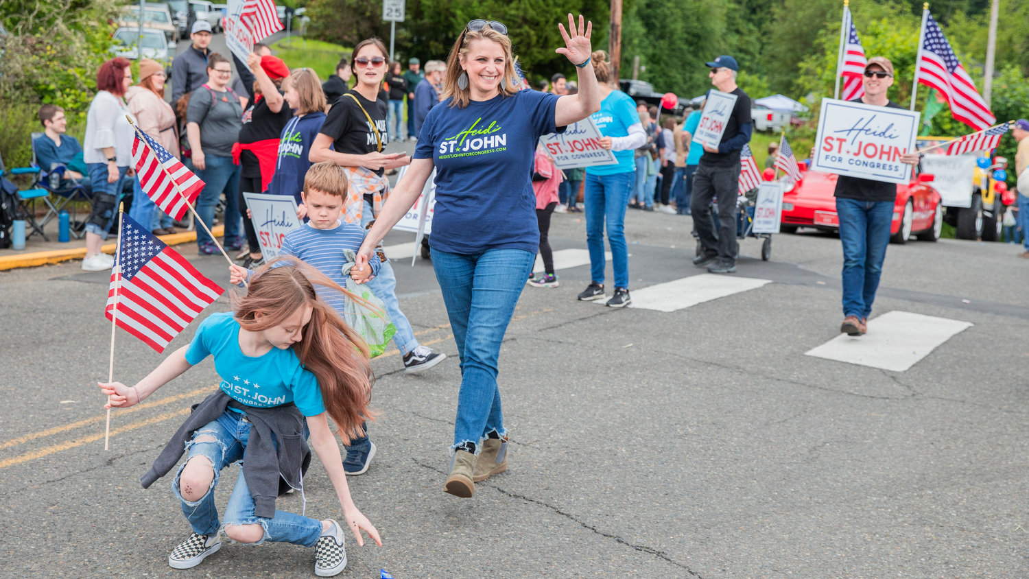 Heidi St. John smiles and waves alongside sign holders during the Egg Days Festival parade in Winlock on Saturday.