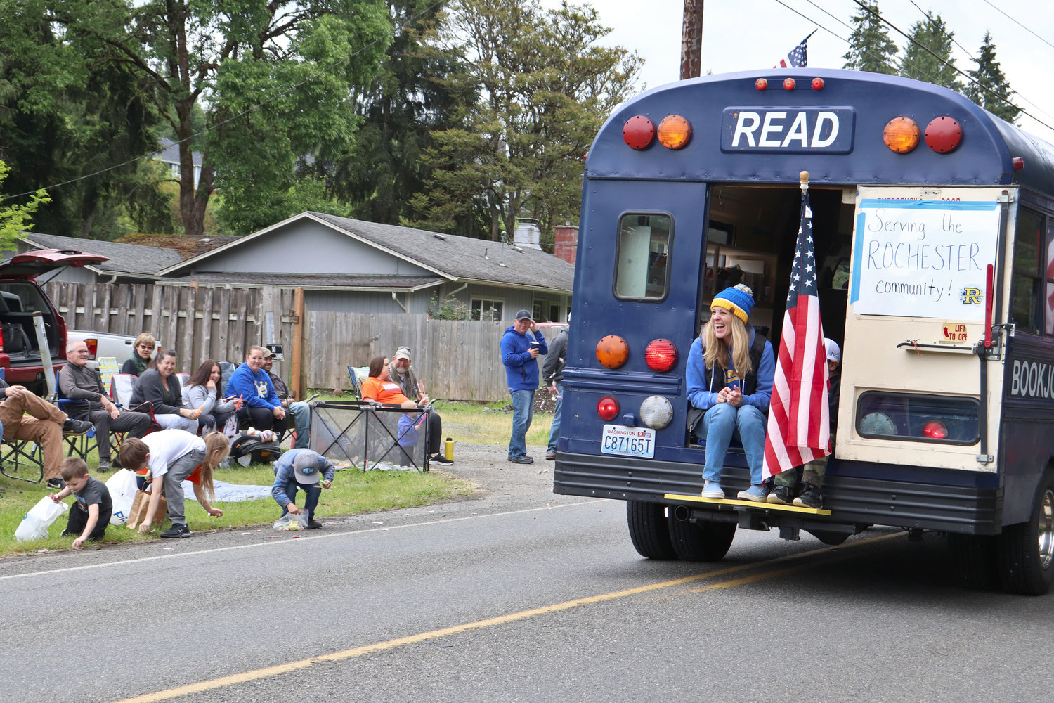 Children gather candy in the wake of the BookJoy Book Bus, a mobile library that serves the Rochester community, during the Swede Day Parade in Rochester on Saturday.