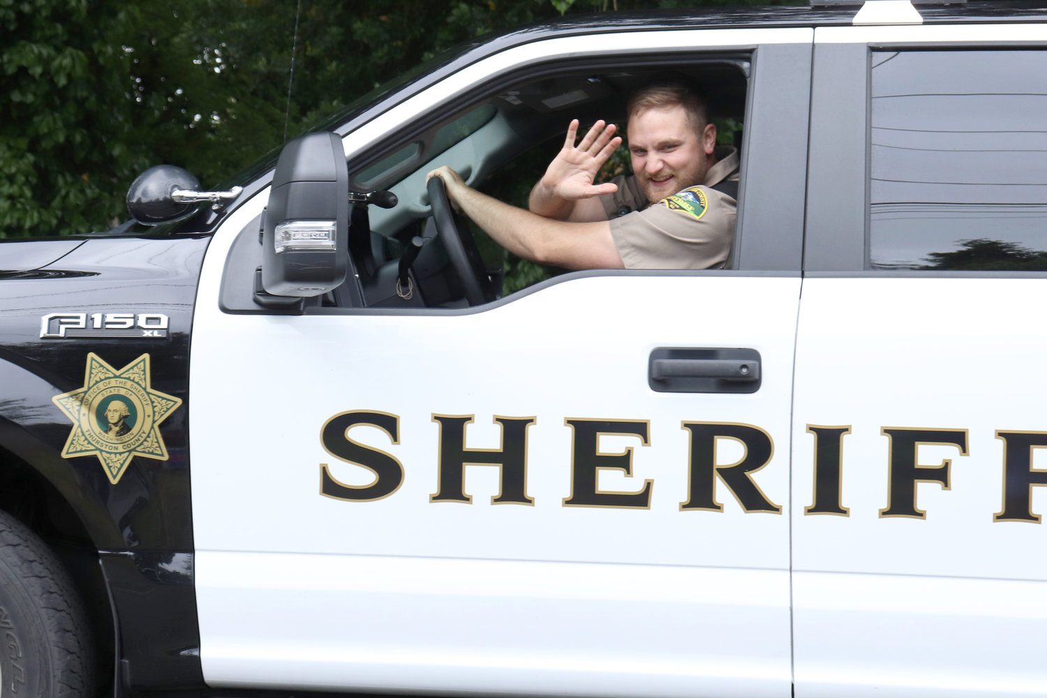 A deputy with the Thurston County Sheriff’s Office waves during the Swede Day Parade in Rochester on Saturday.