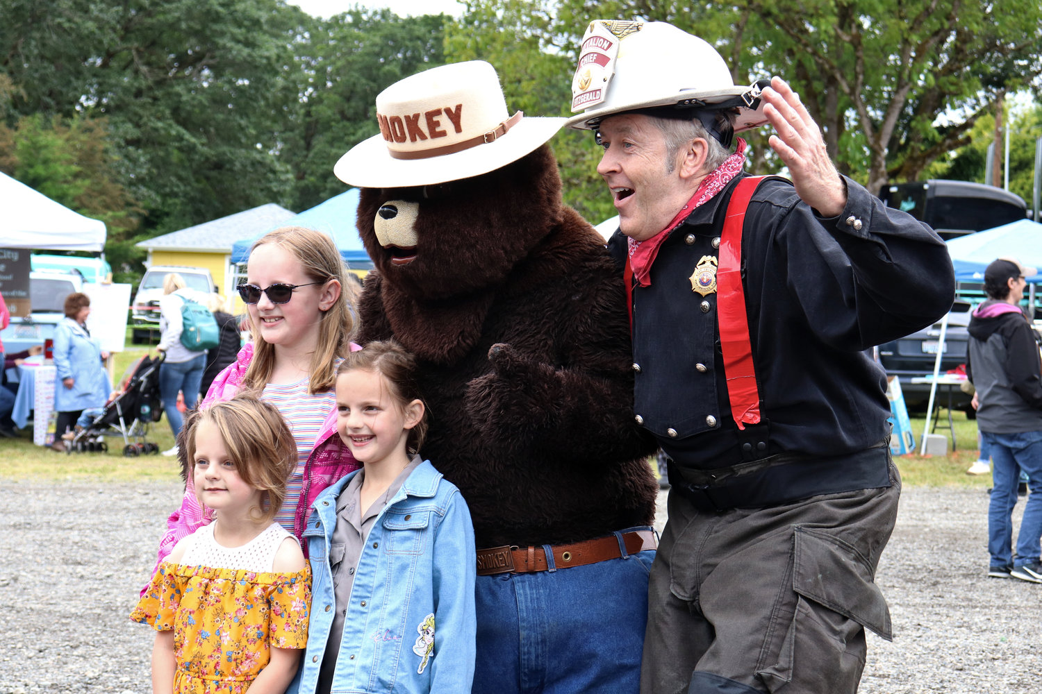 Smokey the Bear and Tom Fitzgerald, a battalion chief for West Thurston Regional Fire Authority, pose for photos with children attending the Swede Day celebration in Rochester on Saturday.