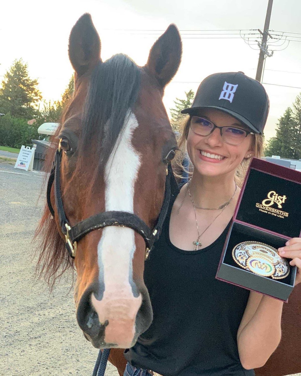Adna junior Savanna Ridley holds up her first place buckle in a photo with her horse Guido after earning the gold in reining.
