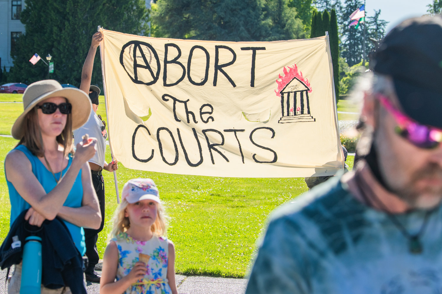 A sign reads“Abort the courts” during a protest Friday afternoon in Olympia.