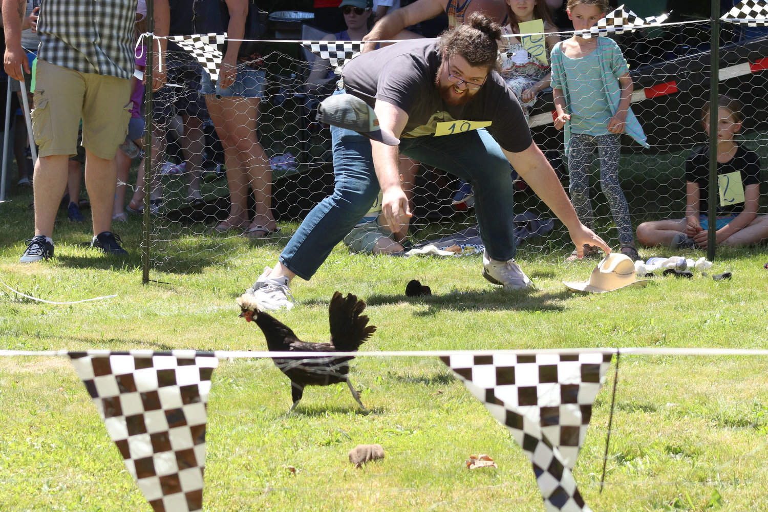 Parker Ashton throws a cap at a chicken during Independence Valley Community Hall’s 42nd Annual Chicken Races in Rochester on Sunday.
