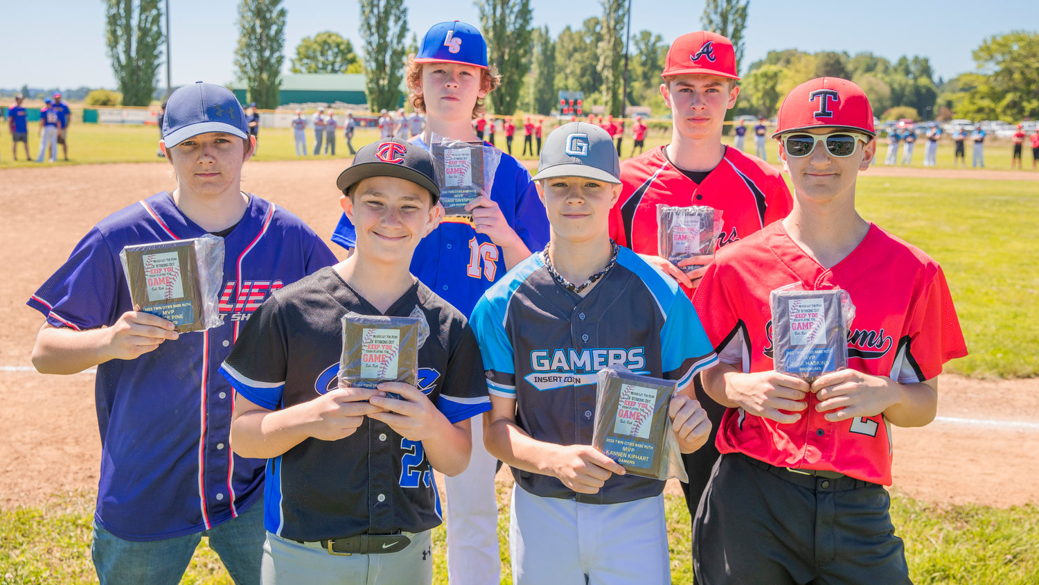 MVP’s hold up plaques during closing ceremonies at Stan Hedwall Park in Chehalis on Saturday.