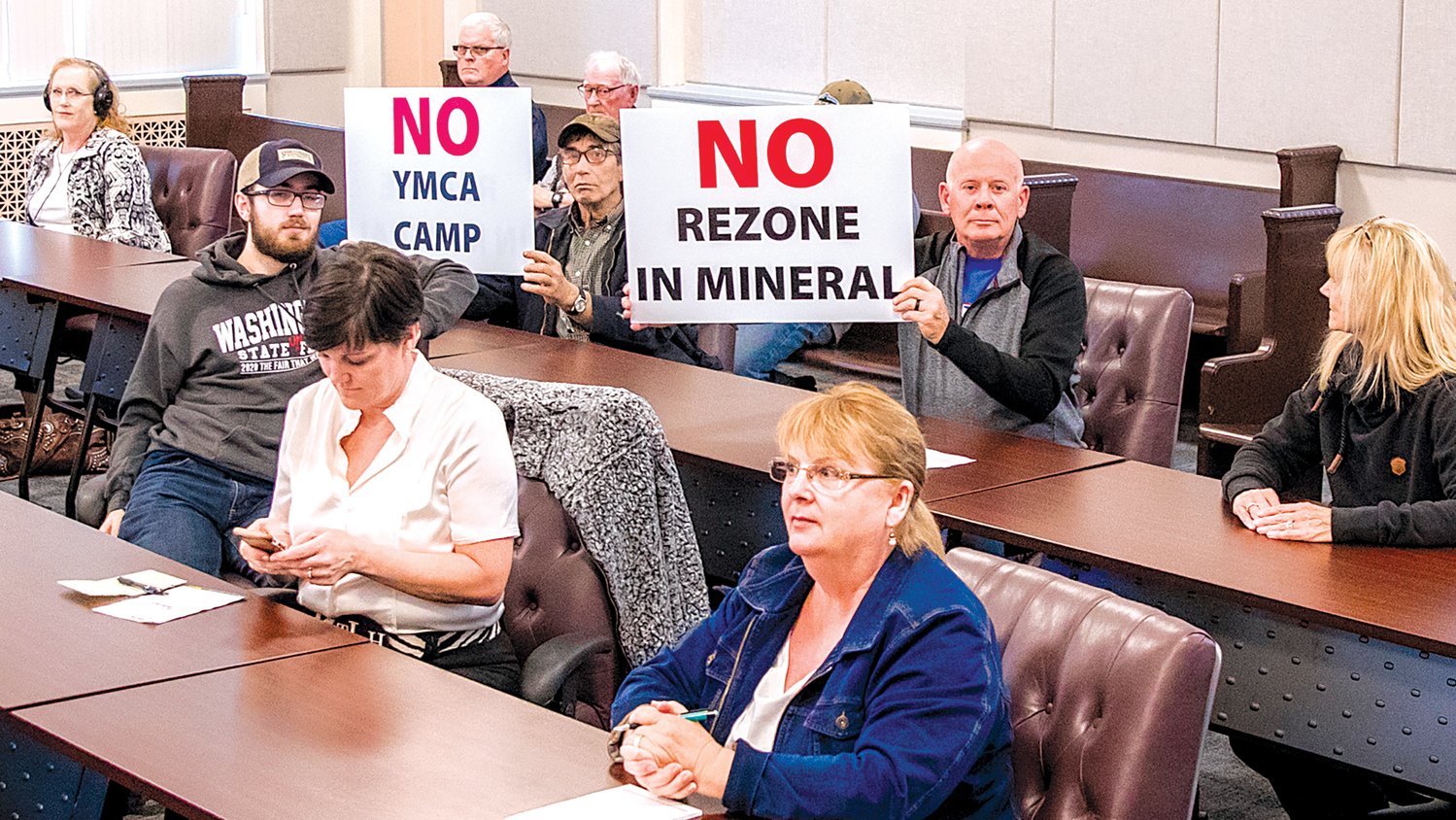 Dave Cunningham and Mike Heinz hold signs during a public hearing held by the Lewis County Planning Commission at the Lewis County Courthouse in Chehalis Tuesday evening on a rezone proposal north of Mineral Lake.